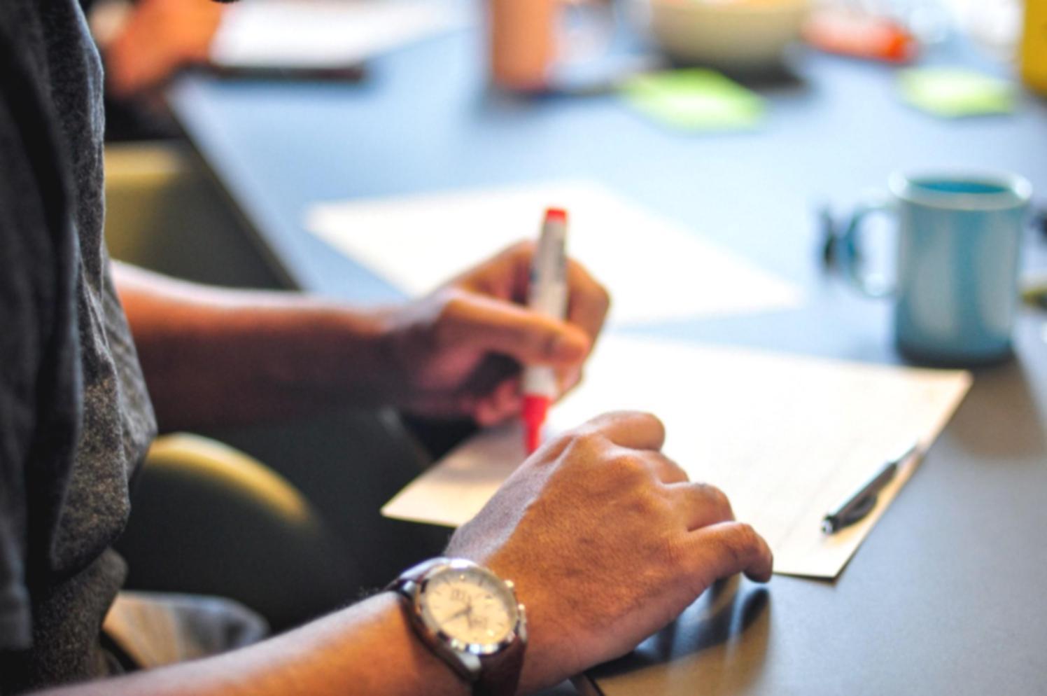 Student reviewing financial planning materials on laptop with notebook